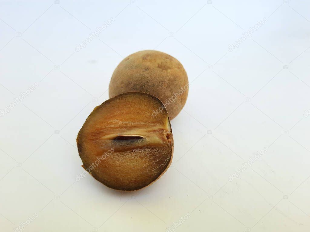 Closeup of beautiful full and half sliced Brown color Chickoo or Sapota Fruit isolated on white background