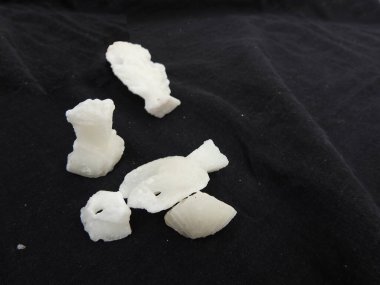 Pongal veya Makara Sankranti Festivali 'nde dağıtım için beyaz rengin farklı şekillerdeki şeker küfleri siyah arkaplanda izole edildi