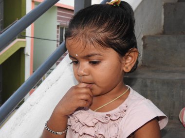 Güzel bir Hintli kız dışarıda mor renkli balonla oynuyor ve eğleniyor