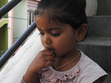 Güzel bir Hintli kız dışarıda mor renkli balonla oynuyor ve eğleniyor