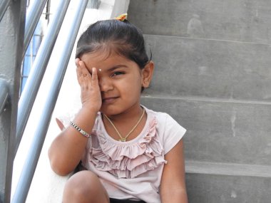 Güzel bir Hintli kız dışarıda mor renkli balonla oynuyor ve eğleniyor