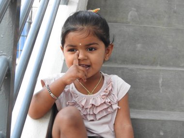 Güzel bir Hintli kız dışarıda mor renkli balonla oynuyor ve eğleniyor