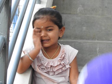 Güzel bir Hintli kız dışarıda mor renkli balonla oynuyor ve eğleniyor