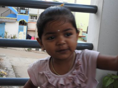 Güzel bir Hintli kız dışarıda mor renkli balonla oynuyor ve eğleniyor