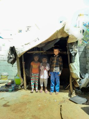 Bangalore, Karnataka, Hindistan-Mar 06-2021: Maske takan fakir çocukların yakın çekimi Bangalore City 'deki küçük bir çatı çadırında kalıyor