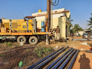Bangalore, Karnataka, Hindistan-07 Mart 2021: Bayanlar başlamadan önce Borewell Sondaj Kamyonu veya araçları aletler, boru, makine ve çalışma gücü ve puja ile kapatıldı