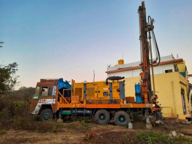 Bangalore, Karnataka, Hindistan-07 Mart 2021: Bayanlar başlamadan önce Borewell Sondaj Kamyonu veya araçları aletler, boru, makine ve çalışma gücü ve puja ile kapatıldı