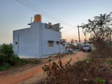 Bangalore, Karnataka, Hindistan-Mar 07 2021: Modern, tek katlı bir binanın kapanışı orman veya kırsal bir alana park ediliyor