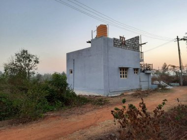 Bangalore, Karnataka, Hindistan-Mar 07 2021: Modern, tek katlı bir binanın kapanışı orman veya kırsal bir alana park ediliyor