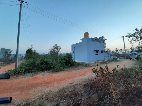 Bangalore, Karnataka, Hindistan-Mar 07 2021: Modern, tek katlı bir binanın kapanışı orman veya kırsal bir alana park ediliyor