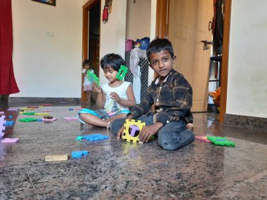 Bangalore, Karnataka, Hindistan-Mar 13 2021: Bir grup çocuk İngiliz alfabesini kullanarak oyun oynuyor ve evin içinde lastik veya köpük minderi numaralandırıyor.