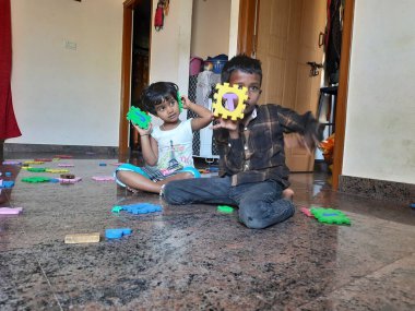 Bangalore, Karnataka, Hindistan-Mar 13 2021: Bir grup çocuk İngiliz alfabesini kullanarak oyun oynuyor ve evin içinde lastik veya köpük minderi numaralandırıyor.