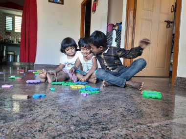 Bangalore, Karnataka, Hindistan-Mar 13 2021: Bir grup çocuk İngiliz alfabesini kullanarak oyun oynuyor ve evin içinde lastik veya köpük minderi numaralandırıyor.