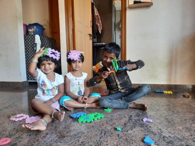 Bangalore, Karnataka, Hindistan-Mar 13 2021: Bir grup çocuk İngiliz alfabesini kullanarak oyun oynuyor ve evin içinde lastik veya köpük minderi numaralandırıyor.