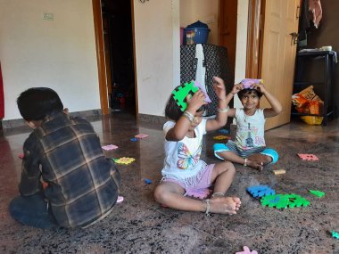 Bangalore, Karnataka, Hindistan-Mar 13 2021: Bir grup çocuk İngiliz alfabesini kullanarak oyun oynuyor ve evin içinde lastik veya köpük minderi numaralandırıyor.