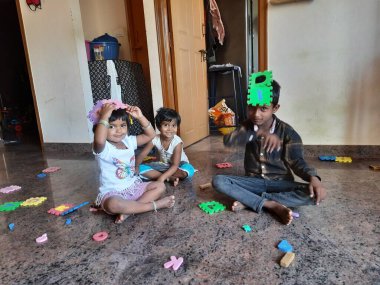 Bangalore, Karnataka, Hindistan-Mar 13 2021: Bir grup çocuk İngiliz alfabesini kullanarak oyun oynuyor ve evin içinde lastik veya köpük minderi numaralandırıyor.