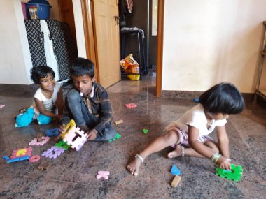 Bangalore, Karnataka, Hindistan-Mar 13 2021: Bir grup çocuk İngiliz alfabesini kullanarak oyun oynuyor ve evin içinde lastik veya köpük minderi numaralandırıyor.