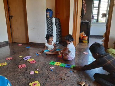 Bangalore, Karnataka, Hindistan-Mar 13 2021: Bir grup çocuk İngiliz alfabesini kullanarak oyun oynuyor ve evin içinde lastik veya köpük minderi numaralandırıyor.