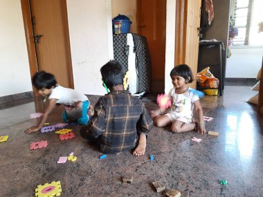 Bangalore, Karnataka, Hindistan-Mar 13 2021: Bir grup çocuk İngiliz alfabesini kullanarak oyun oynuyor ve evin içinde lastik veya köpük minderi numaralandırıyor.