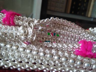 Kırmızı arka planda izole edilmiş bacaklar için gümüş zincir ya da bileklik koleksiyonu.