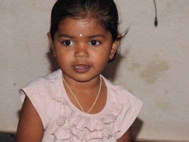 Bangalore, Karnatka, Hindistan-26 Aralık 2020: Evde tek başına Buguri ya da bambaram oynayan Hintli şirin kız çocuğunun yakın çekimi ve büyük anneler bunu görüyor