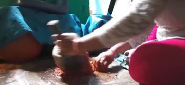 Channapatna, Karnataka, Hindistan-Mar 14 2021: Masala ya da Chutney 'i geleneksel olarak öğüten Hintli Kız