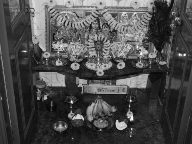 Bangalore, Karnataka, Hindistan-31 Temmuz 2020: Güzel Hint Puja Odası 'nın kapanışı bir tabağa yerleştirilmiş rupi notları, tanrıların fotoğrafı ve çiçeklerle süslenmiş kalaşnikof.