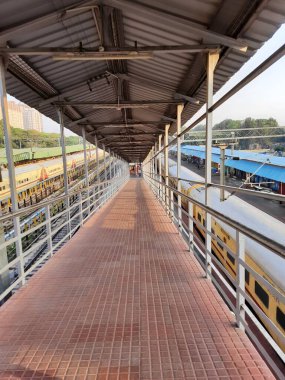 Bangalore, Karnataka, India-Apr 07 2021: Yesvantpur Junction tren istasyonunun kapatılması istasyon koridoru, yürüyen merdiven, yaya yolu, küçük bir dükkan ve sembollü bir platformda trenler