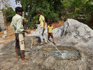 Bangalore, Karnataka, Hindistan-Nisan 10 2021: Hintli işçilerin yeni bina inşaatı, su kuyusu ve inşaat malzemelerini su kullanarak karıştırması.