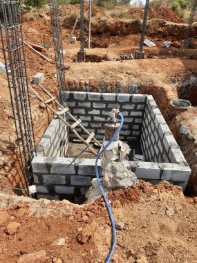 Bangalore, Karnataka, Hindistan-Nisan 10 2021: Sütun, kiriş, çukur ve su kuyusu inşaatının çimento bloğu kullanılarak inşa edilmesi