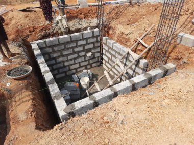 Bangalore, Karnataka, Hindistan-Nisan 10 2021: Sütun, kiriş, çukur ve su kuyusu inşaatının çimento bloğu kullanılarak inşa edilmesi