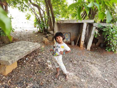 Bangalore, Karnataka, Hindistan-10 Nisan 2021: Kameraya poz vererek parkta oynayan güzel Hintli çocuk