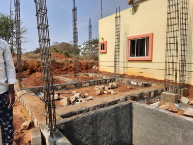 Bangalore, Karnataka, Hindistan-Nisan 17 2021: Kum, taş, boras gibi malzemelerle temel ilk iş veya inşaat, sump, sütun, kiriş ve paya gibi yapıların kapatılması.,