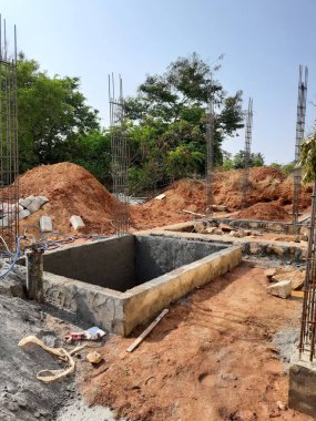 Bangalore, Karnataka, Hindistan-Nisan 17 2021: Kum, taş, boras gibi malzemelerle temel ilk iş veya inşaat, sump, sütun, kiriş ve paya gibi yapıların kapatılması.,