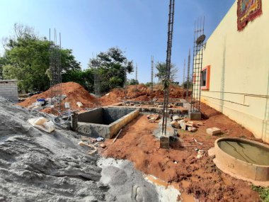 Bangalore, Karnataka, Hindistan-Nisan 17 2021: Kum, taş, boras gibi malzemelerle temel ilk iş veya inşaat, sump, sütun, kiriş ve paya gibi yapıların kapatılması.,