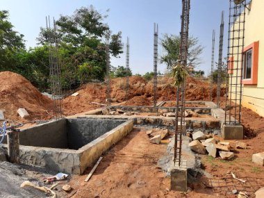 Bangalore, Karnataka, Hindistan-Nisan 17 2021: Kum, taş, boras gibi malzemelerle temel ilk iş veya inşaat, sump, sütun, kiriş ve paya gibi yapıların kapatılması.,