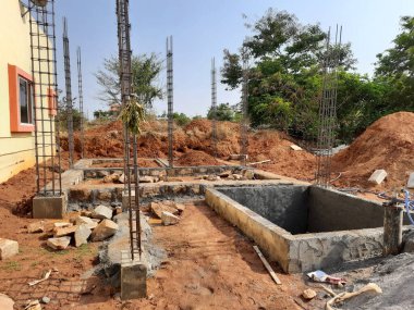 Bangalore, Karnataka, Hindistan-Nisan 17 2021: Kum, taş, boras gibi malzemelerle temel ilk iş veya inşaat, sump, sütun, kiriş ve paya gibi yapıların kapatılması.,