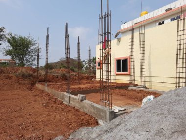Bangalore, Karnataka, Inida-Apr 23 2021: Temelde konut inşaatı ve toprağının kapatılması, sütun için demir çubuklar