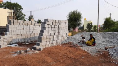 Bangalore, Karnataka, Hindistan-30 Nisan 2021: Yeni bina inşaatı ve temizlik evi gören Hintli genç anne ve çocuğun yakın çekimi