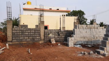 Bangalore, Karnataka, Hindistan-30 Nisan 2021: Yeni bina inşaatı ve temizlik evi gören Hintli genç anne ve çocuğun yakın çekimi