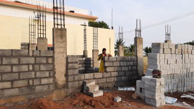 Bangalore, Karnataka, Hindistan-30 Nisan 2021: Yeni bina inşaatı ve temizlik evi gören Hintli genç anne ve çocuğun yakın çekimi