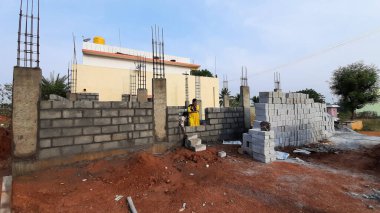 Bangalore, Karnataka, Hindistan-30 Nisan 2021: Yeni bina inşaatı ve temizlik evi gören Hintli genç anne ve çocuğun yakın çekimi