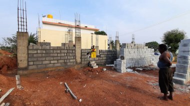 Bangalore, Karnataka, Hindistan-30 Nisan 2021: Yeni bina inşaatı ve temizlik evi gören Hintli genç anne ve çocuğun yakın çekimi