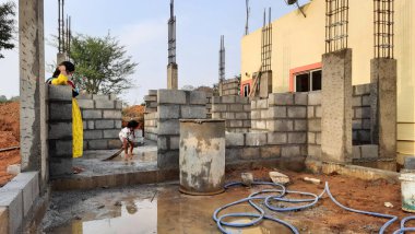 Bangalore, Karnataka, Hindistan-30 Nisan 2021: Yeni bina inşaatı ve temizlik evi gören Hintli genç anne ve çocuğun yakın çekimi