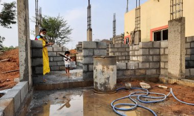 Bangalore, Karnataka, Hindistan-30 Nisan 2021: Yeni bina inşaatı ve temizlik evi gören Hintli genç anne ve çocuğun yakın çekimi