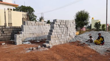 Bangalore, Karnataka, Hindistan-30 Nisan 2021: Yeni bina inşaatı ve temizlik evi gören Hintli genç anne ve çocuğun yakın çekimi