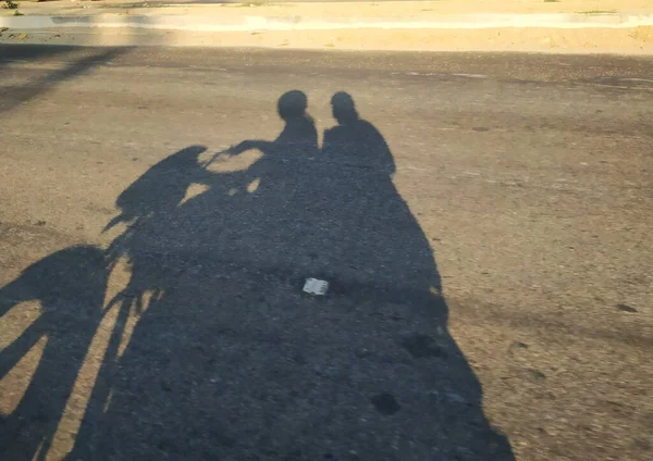 Closeup Shadow Asphalt Road Men Driving Bike Girl Sitting Back — Stock Photo, Image