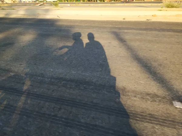 Closeup Shadow Asphalt Road Men Driving Bike Girl Sitting Back — Stock Photo, Image