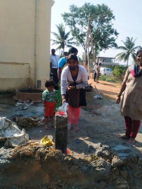 Bangalore, Karnataka, Hindistan-07 Mart 2021: İnşaat başlamadan önce bölgede puja yapan Hintli geleneksel kız ve kadınların yakınlaşması.