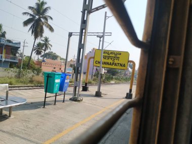 Channapatna, Karnataka, Hindistan-Nisan 07 2021: Trenlerin, platformların, yürüyen insanların ve Channapatna Tren İstasyonu 'nun isim panosunun kapatılması